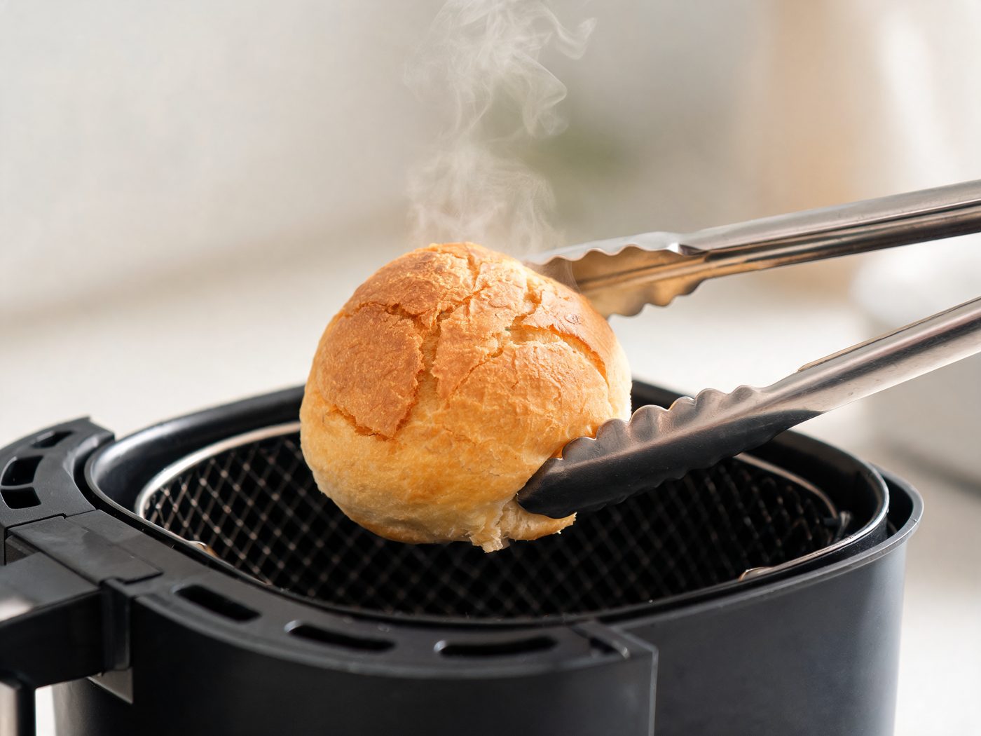 Pão dourado saindo da cesta da air fryer
